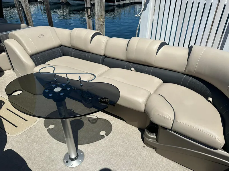 Slide: The Image of Luxurious seating on 2018 Avalon Catalina Platinum Entertainer boat with glass table, docked by water. - 20