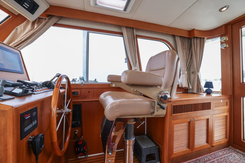 Slide: The Image of Helm station of 2008 Grand Banks EASTBAY 39 SX with leather chair and wooden steering wheel. - 12