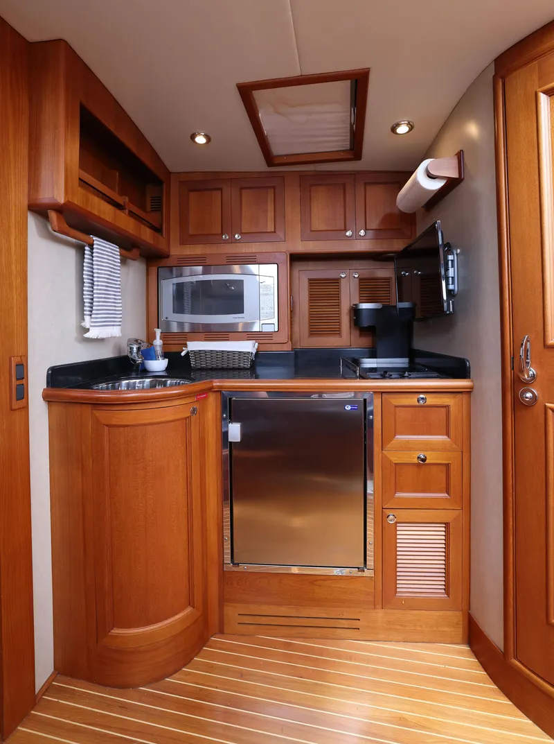 Slide: The Image of Luxurious 2008 Grand Banks EASTBAY 39 SX yacht kitchen with wood cabinetry and modern appliances. - 22