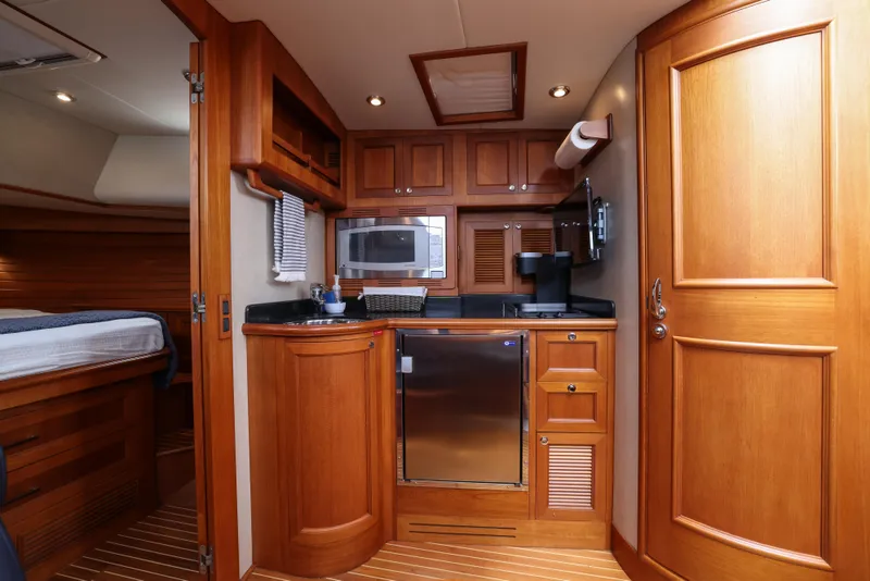 Slide: The Image of Luxurious 2008 Grand Banks EASTBAY 39 SX yacht interior with wood cabinetry and modern amenities. - 23