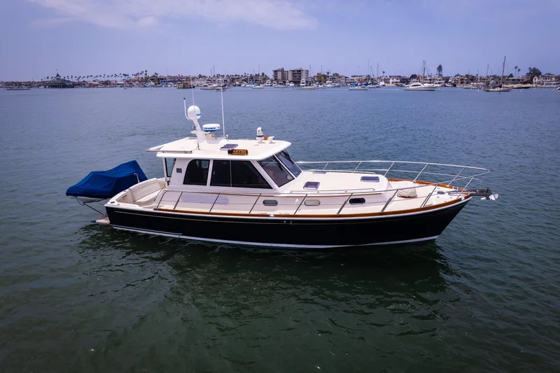 Slide: The Image of 2008 Grand Banks EASTBAY 39 SX yacht on calm water, cityscape in background. - 31