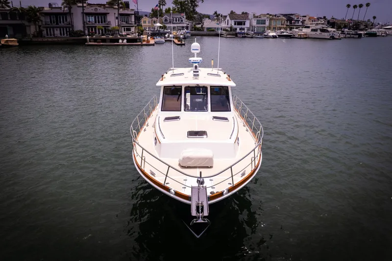 Slide: The Image of 2008 Grand Banks EASTBAY 39 SX yacht on calm water, with waterfront homes in the background. - 32