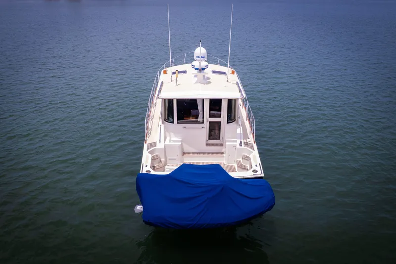 Slide: The Image of 2008 Grand Banks EASTBAY 39 SX yacht on calm water, rear view with blue cover. - 36