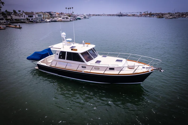 Slide: The Image of 2008 Grand Banks EASTBAY 39 SX yacht on calm water, coastal homes in background. - 37