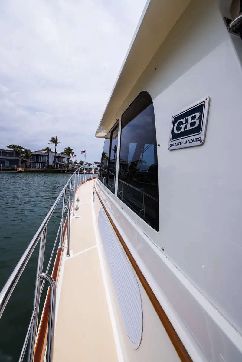 Slide: The Image of 2008 Grand Banks EASTBAY 39 SX yacht, side view, cruising near waterfront homes. - 9