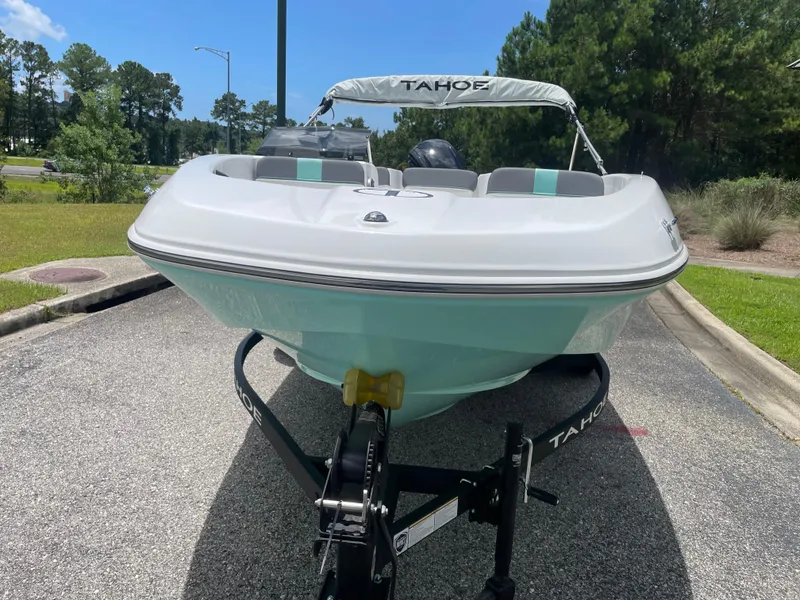 Slide: The Image of 2025 Tahoe T16 boat on trailer, parked on a sunny day, surrounded by greenery. - 2