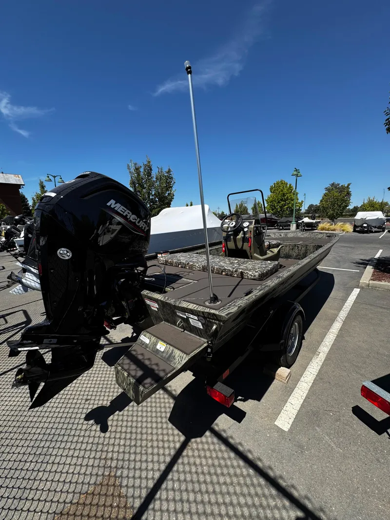 Slide: The Image of 2025 Tracker Grizzly 1860 CC boat with Mercury engine in parking lot. - 2