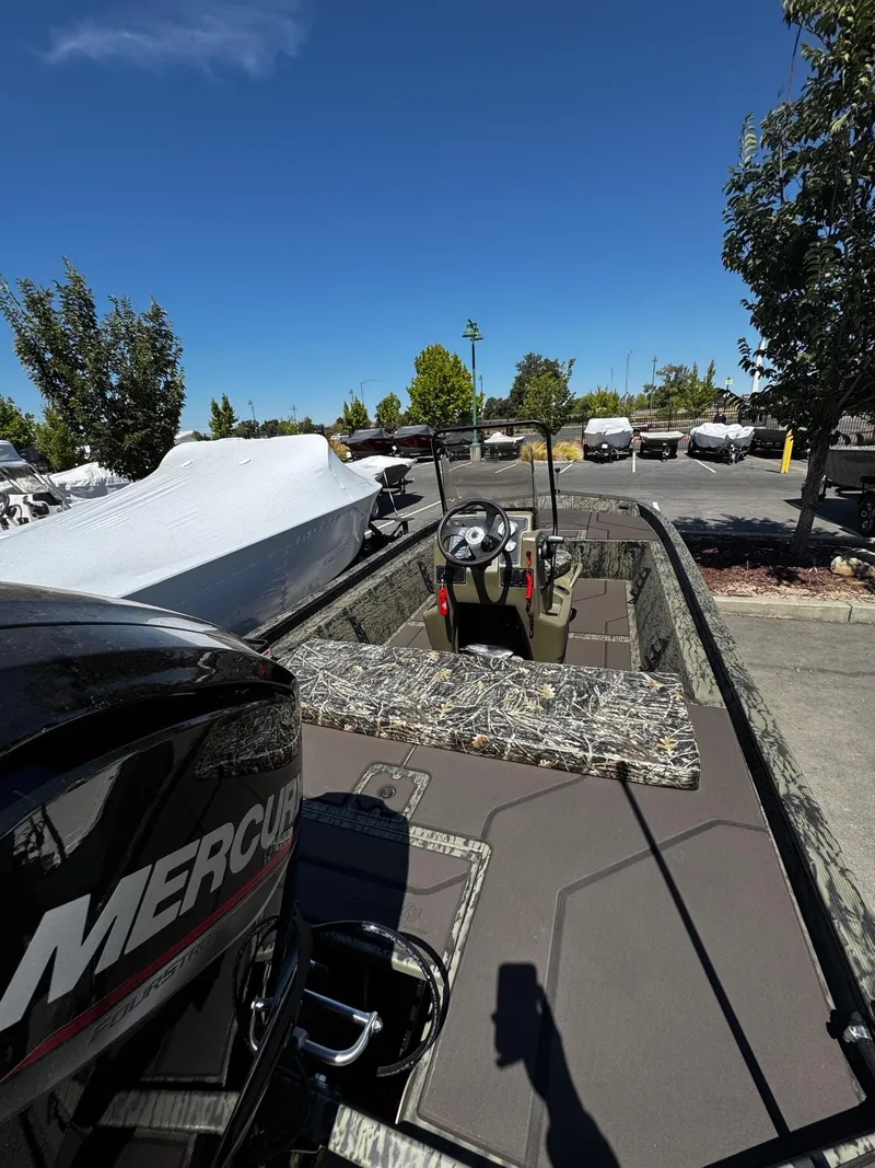 Slide: The Image of 2025 Tracker Grizzly 1860 CC boat with Mercury engine in outdoor setting. - 3