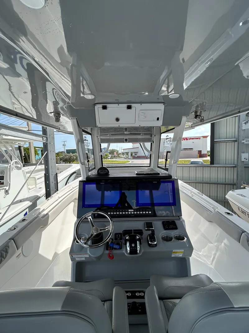 Slide: The Image of 2024 Sea Pro 320 DLX Center Console boat interior with modern dashboard and steering wheel. - 12