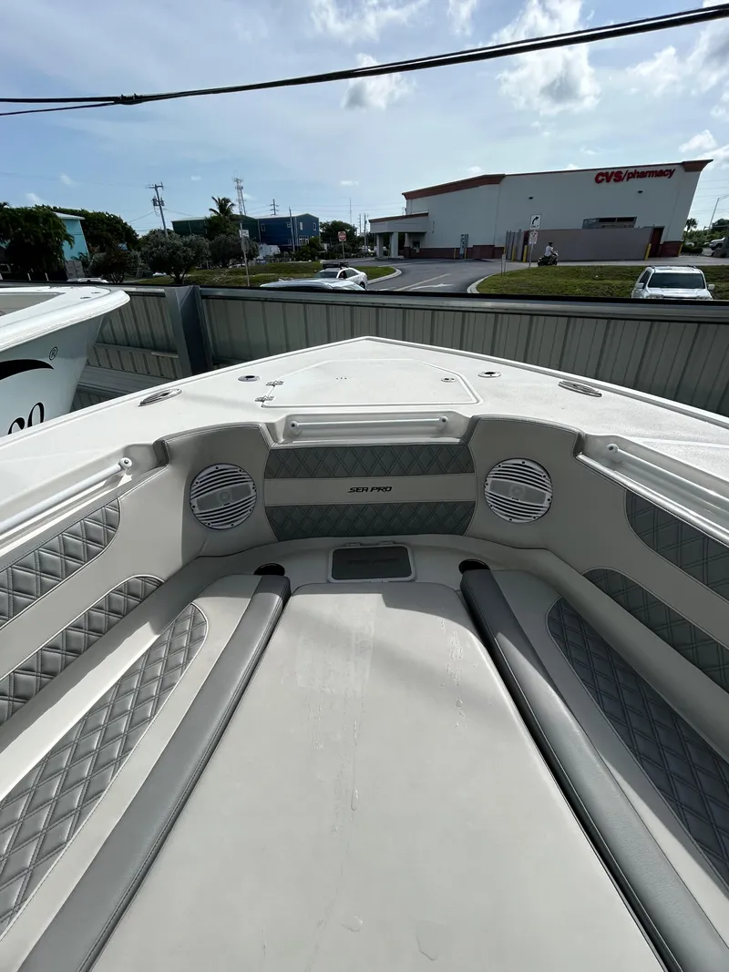 Slide: The Image of 2024 Sea Pro 320 DLX Center Console boat interior with cushioned seating and speakers. - 8