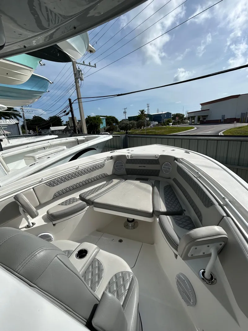 Slide: The Image of 2024 Sea Pro 320 DLX Center Console boat interior with cushioned seating and table. - 9