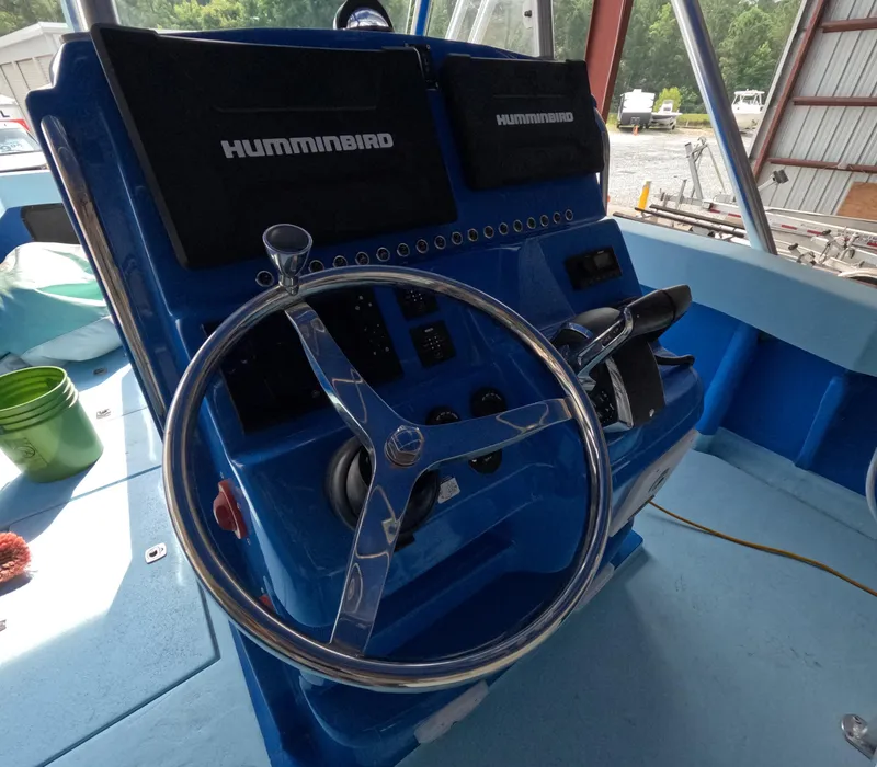 Slide: The Image of 2022 Eastward 30 boat interior with open hatch, blue deck, and water view. - 11