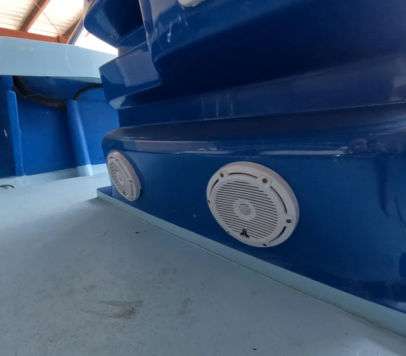 Slide: The Image of 2022 Eastward 30 boat with blue canopy, steering wheel, and seating on calm water. - 19