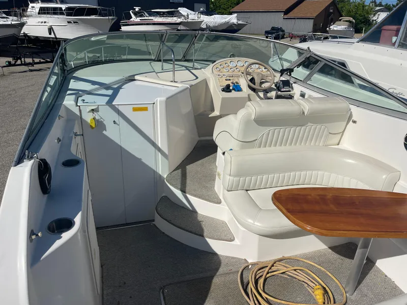 Slide: The Image of 1998 Cruisers 2870 Rogue boat interior with seating, steering wheel, and wooden table. - 15