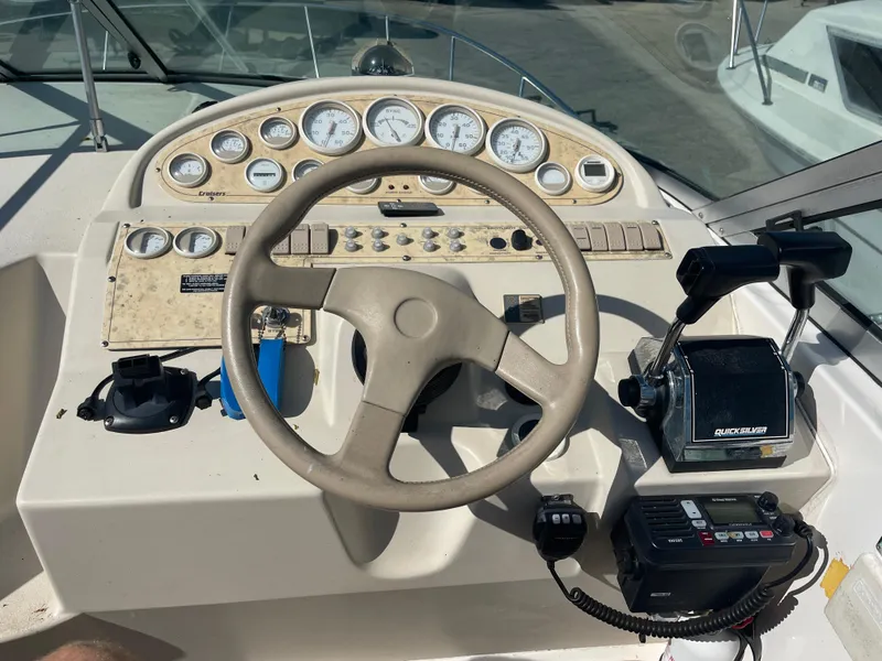 Slide: The Image of 1998 Cruisers 2870 Rogue boat dashboard with steering wheel and control panel. - 18