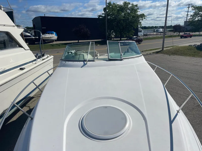 Slide: The Image of 1998 Cruisers 2870 Rogue boat docked, view from bow, clear sky background. - 20