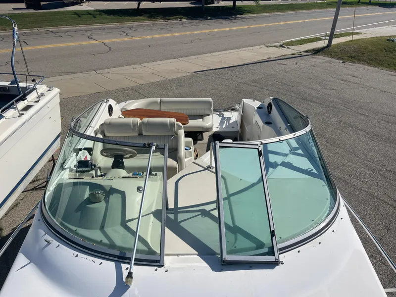 Slide: The Image of 1998 Cruisers 2870 Rogue boat with open cockpit and seating, parked on pavement. - 21