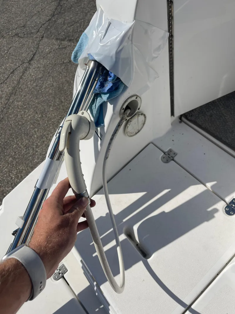 Slide: The Image of Hand holding shower hose on 1998 Cruisers 2870 Rogue boat deck. - 22