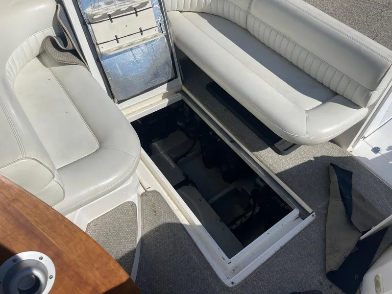 Slide: The Image of 1998 Cruisers 2870 Rogue boat interior with open engine compartment, white seating, and carpeted floor. - 37