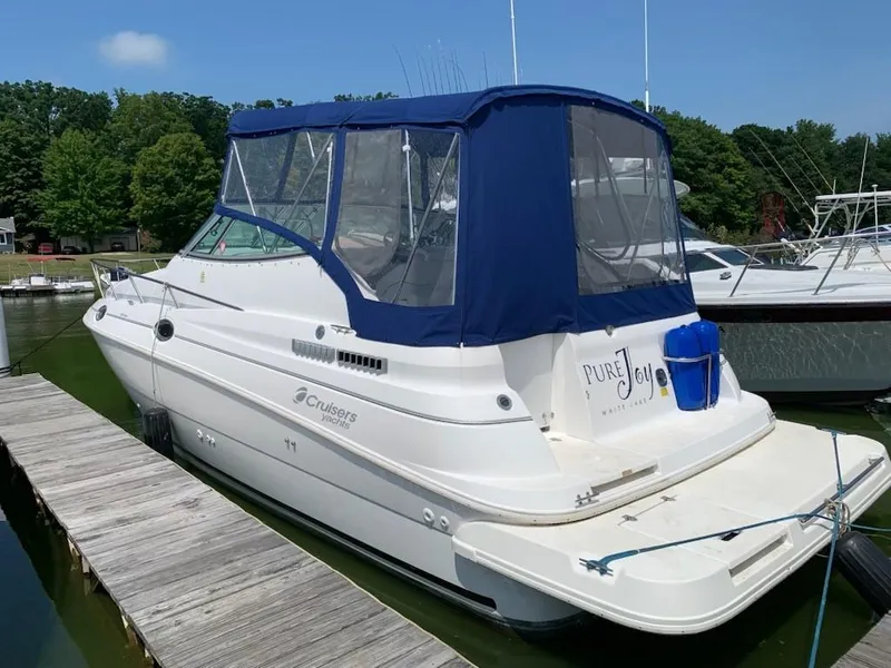 Slide: The Image of 1998 Cruisers 2870 Rogue yacht docked with blue canopy and "Pure Joy" name. - 42