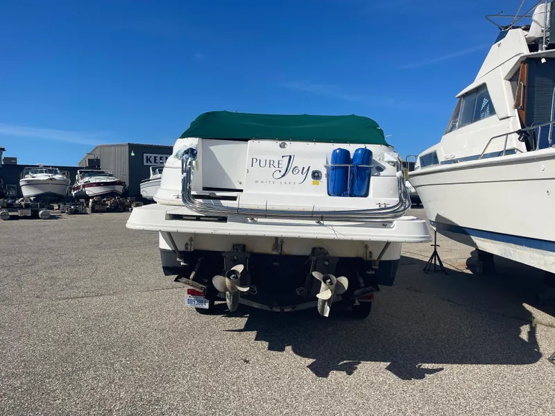 Slide: The Image of 1998 Cruisers 2870 Rogue boat with green cover, docked in a marina. - 8