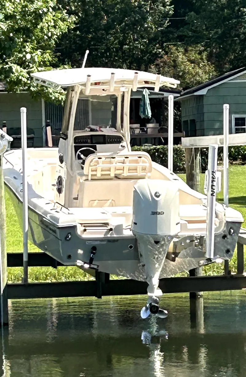 Slide: The Image of 2021 Grady-White 251 Coastal Explorer boat docked near lush greenery. - 14
