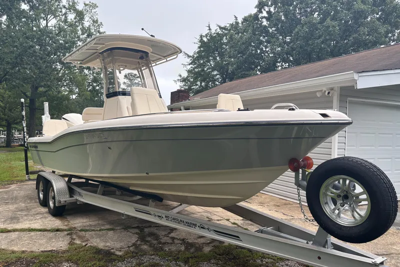 Slide: The Image of 2021 Grady-White 251 Coastal Explorer boat on trailer, parked near a garage. - 3