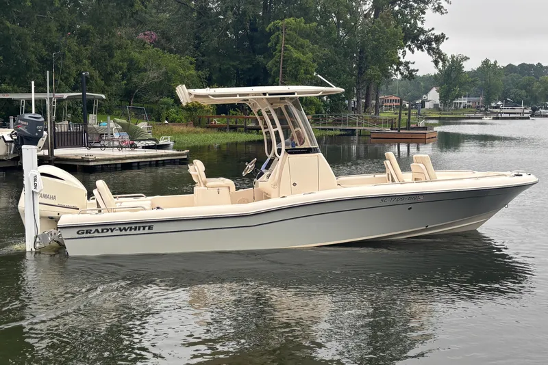 Slide: The Image of 2021 Grady-White 251 Coastal Explorer boat on a calm lake near a dock. - 31