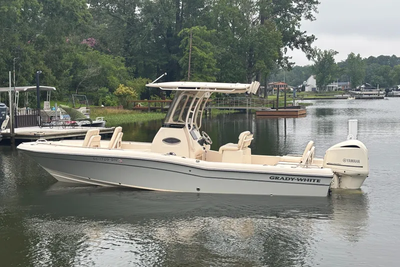Slide: The Image of 2021 Grady-White 251 Coastal Explorer boat on a calm lake with lush greenery. - 33