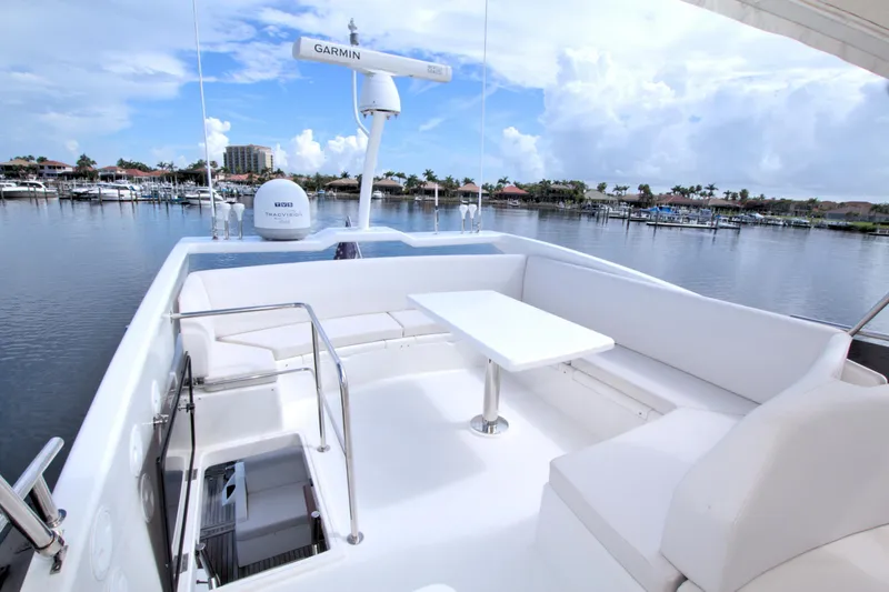 Slide: The Image of Luxurious 2015 Dyna 60 yacht deck with seating, table, and marina view. - 10