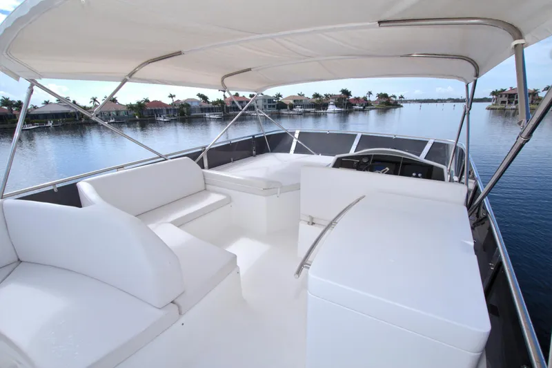 Slide: The Image of Luxurious 2015 Dyna 60 yacht with spacious white seating and canopy on calm waters. - 12