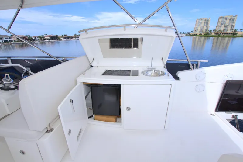 Slide: The Image of Outdoor kitchenette on a 2015 Dyna 60 yacht with sink and storage, overlooking waterfront. - 14