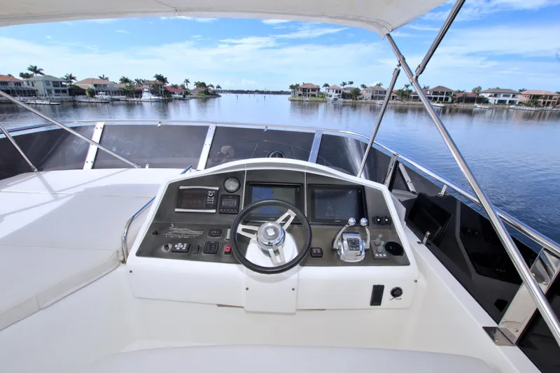 Slide: The Image of Cockpit view of 2015 Dyna 60 yacht with serene waterfront backdrop. - 16