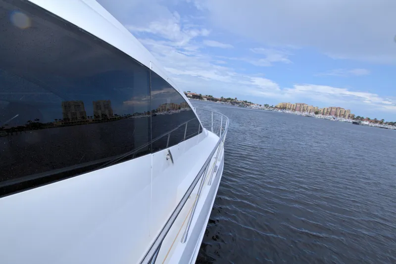 Slide: The Image of Luxury yacht Dyna 60 cruising on a calm sea, cityscape in the background. - 23