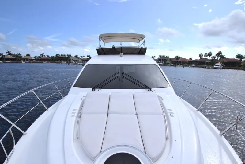 Slide: The Image of 2015 Dyna 60 yacht on calm water, featuring sleek design and spacious deck. - 26