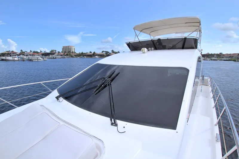 Slide: The Image of Luxury Dyna 60 yacht, 2015 model, cruising on a serene waterfront with clear blue skies. - 27