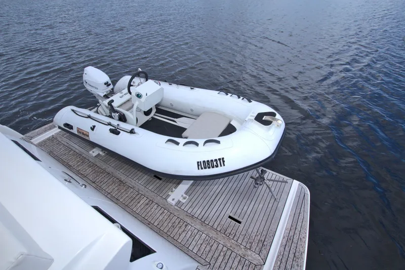 Slide: The Image of Inflatable boat on wooden deck beside water, featuring a 2015 Dyna 60 model. - 30
