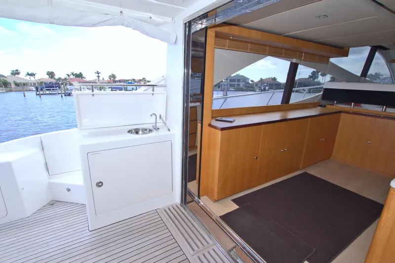 Slide: The Image of Luxurious 2015 Dyna 60 yacht interior with wooden cabinetry and outdoor sink, overlooking marina. - 35