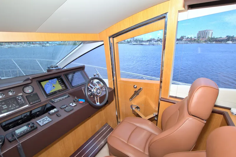 Slide: The Image of Helm of 2015 Dyna 60 yacht with navigation screens and leather captain's chair. - 48