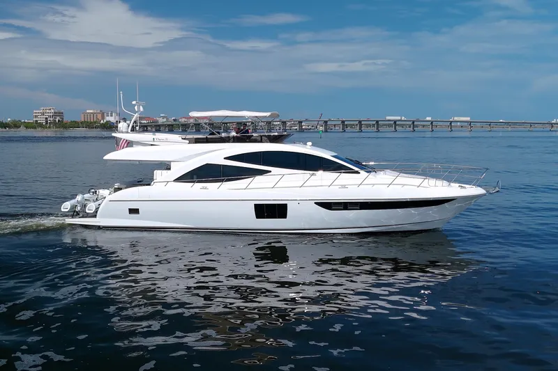 Slide: The Image of Luxurious 2015 Dyna 60 yacht cruising on calm waters with cityscape in the background. - 9