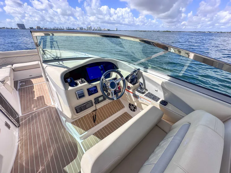Slide: The Image of 2019 Regal 33 OBX boat cockpit with modern controls, steering wheel, and ocean view. - 18