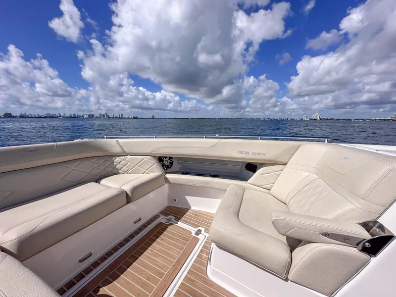 Slide: The Image of Luxurious seating on 2019 Regal 33 OBX boat with ocean view and cloudy sky. - 21