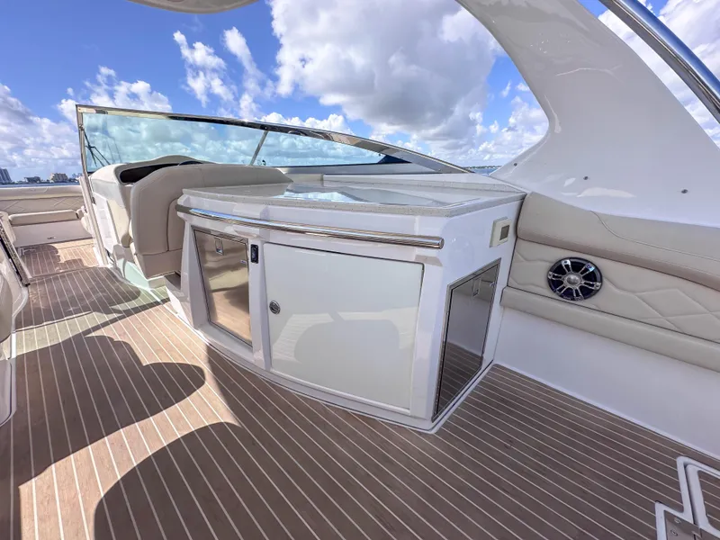 Slide: The Image of 2019 Regal 33 OBX boat interior with sleek cabinetry and seating under a blue sky. - 27