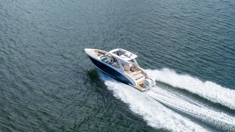 Slide: The Image of 2019 Regal 33 OBX boat cruising on open water, creating a wake. - 3