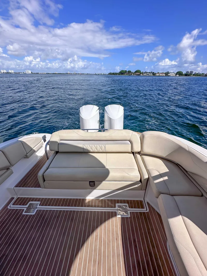 Slide: The Image of 2019 Regal 33 OBX boat with spacious deck and seating, overlooking calm blue waters. - 36