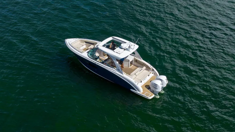 Slide: The Image of 2019 Regal 33 OBX boat cruising on open water, aerial view. - 6