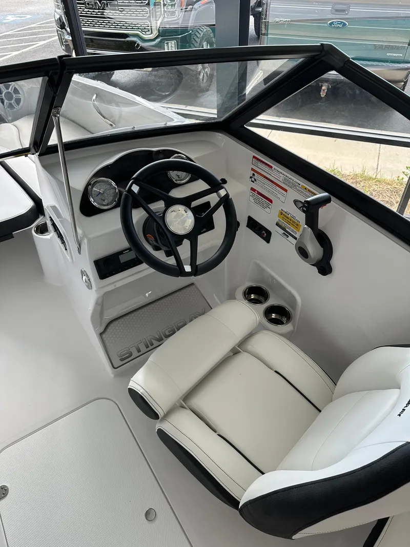 Slide: The Image of 2026 Stingray 191 DC boat interior with steering wheel and white seating. - 3