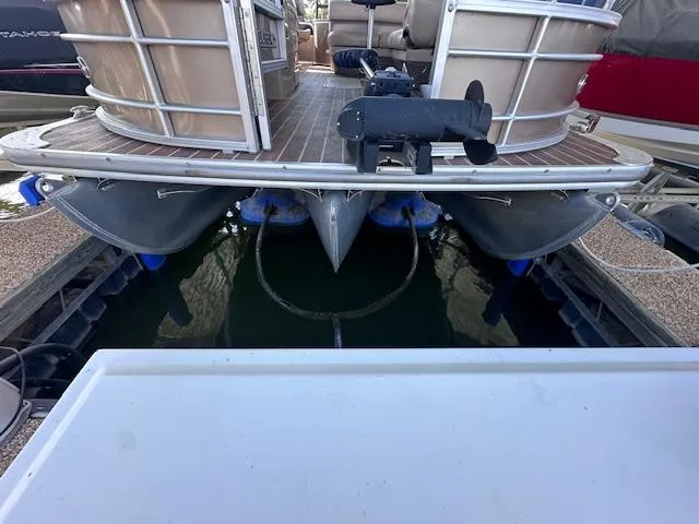 Slide: The Image of Pontoon boat docked, rear view, Xcursion X21F 2015 model, with visible pontoons and deck. - 10