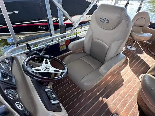 Slide: The Image of Captain's chair and steering wheel on 2015 Xcursion X21F boat, with wood-patterned flooring. - 13