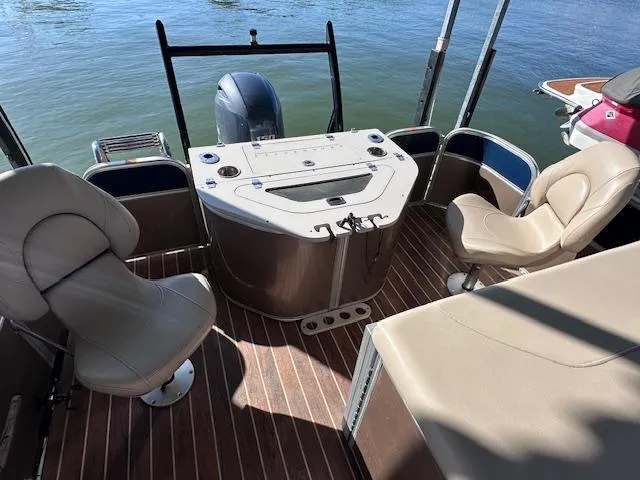 Slide: The Image of 2015 Xcursion X21F boat interior with seating and control panel on water. - 16